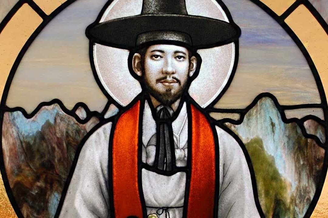 Vitral de Santo André Kim com auréola, chapéu preto de abas largas e estola vermelha