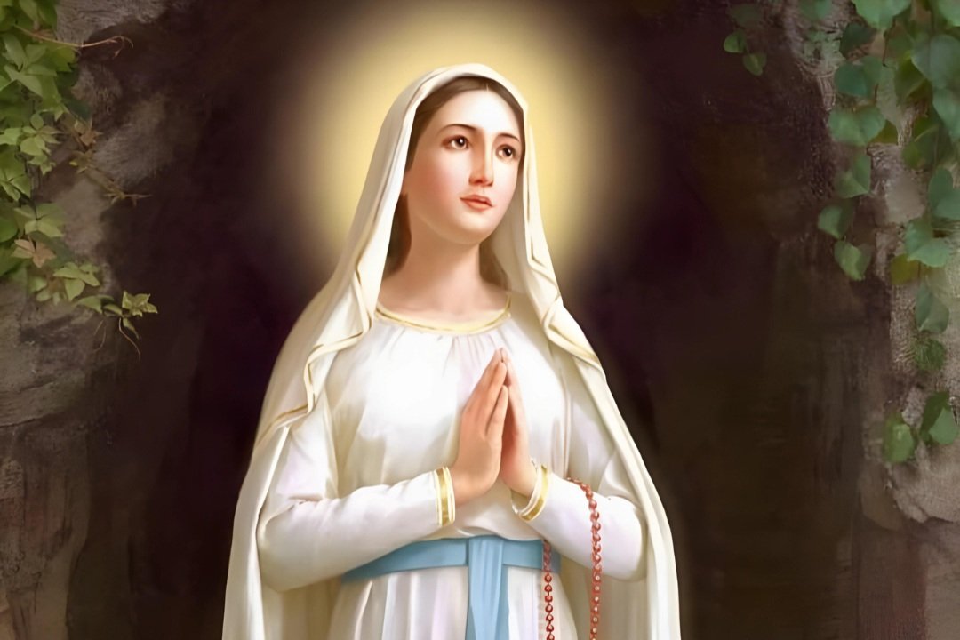 Imagem de Nossa Senhora de Lourdes de mãos postas, com véu branco e faixa azul