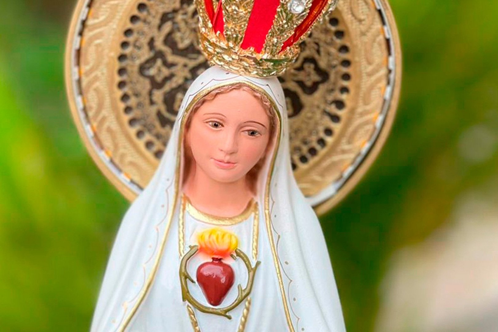 Imagem de Nossa Senhora de Fátima com coroa dourada e o Sagrado Coração visível no peito