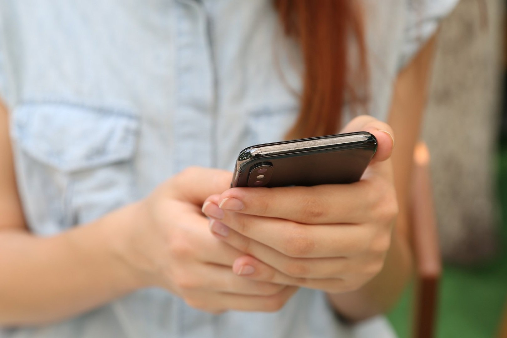 Mãos de uma pessoa segurando um telefone celular