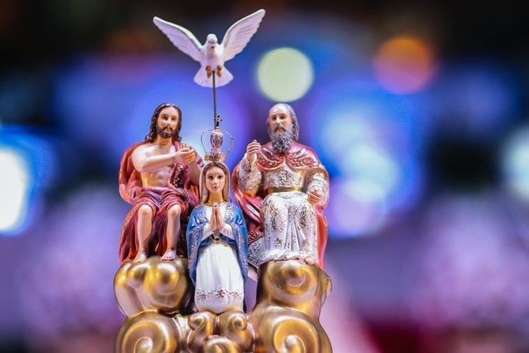 Imagem do Divino Pai Eterno com a pomba do Espírito Santo, sobre um altar iluminado
