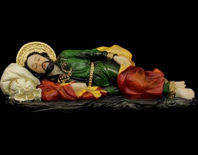 Estátua de São José Deitado em vestes verdes e vermelhas, reclinado sobre fundo escuro