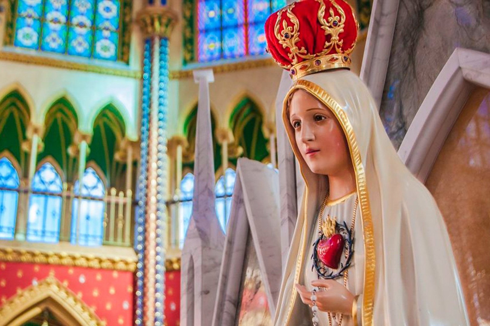 Imagem de Nossa Senhora com o Imaculado Coração no peito, dentro de uma igreja